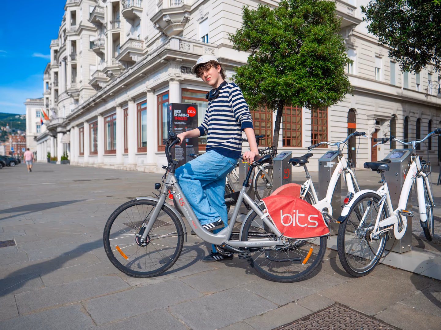 ragazza su una bicicletta bits sulle rive di Trieste, vicino ad una ciclostazione